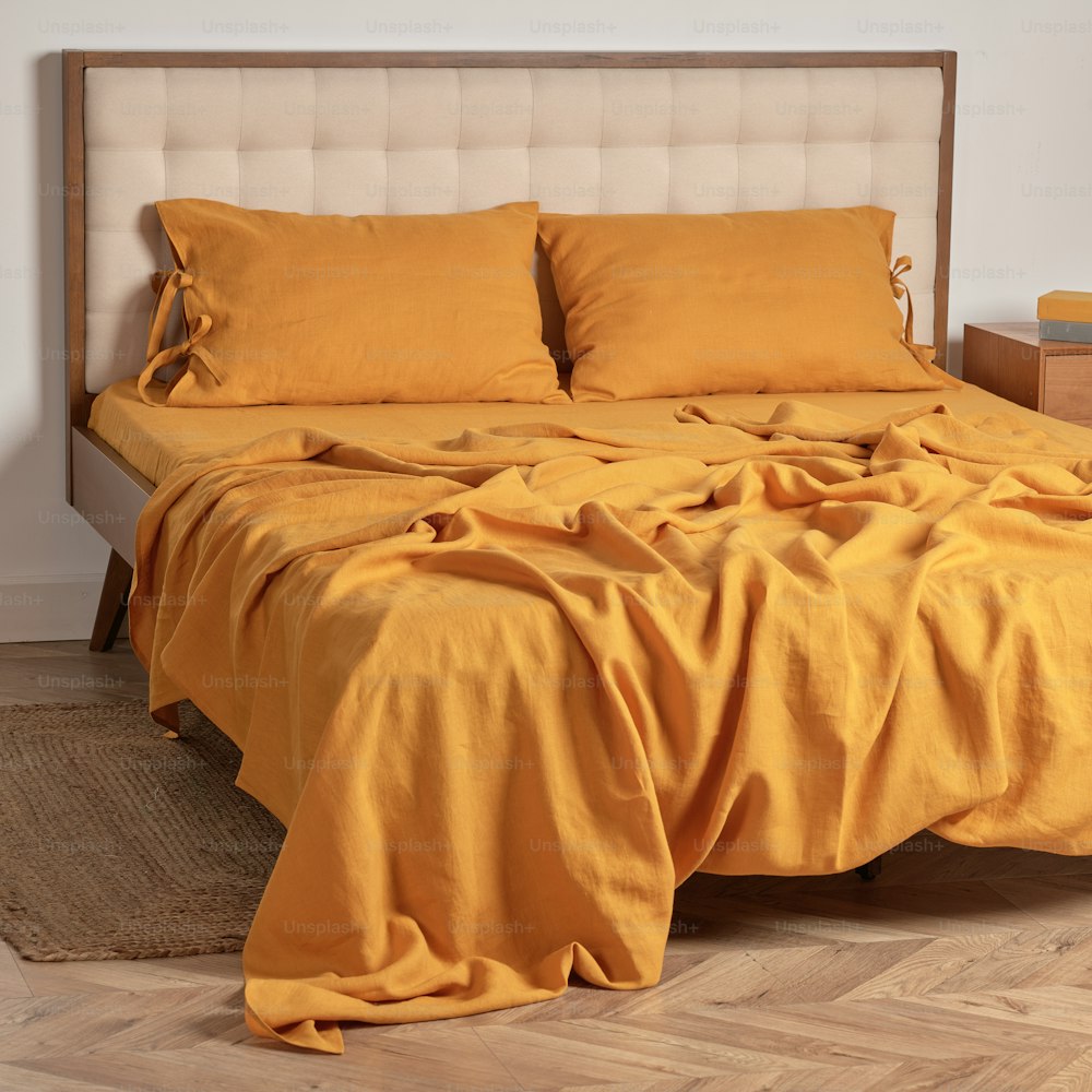 una cama con edredón amarillo y almohadas