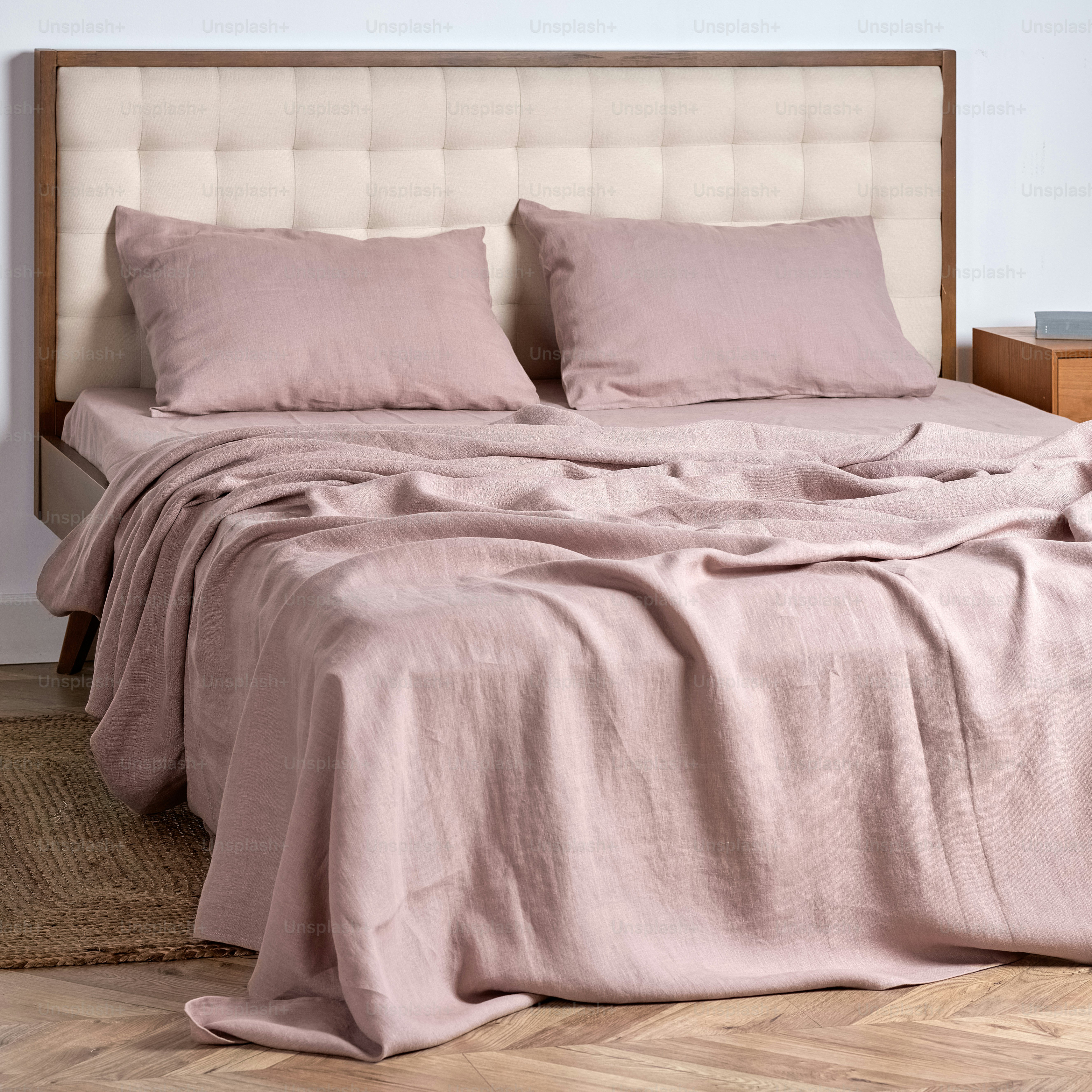 a bed with two pillows and a blanket on top of it