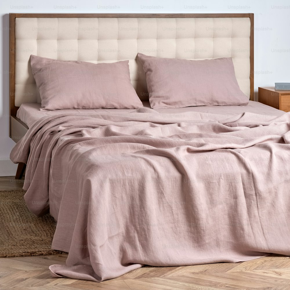 una cama con dos almohadas y una manta encima