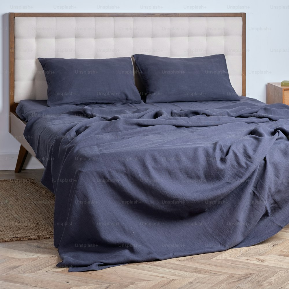 una cama con dos almohadas y una manta encima