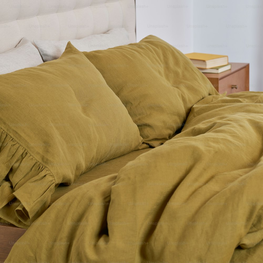 a bed with a yellow comforter and a white headboard