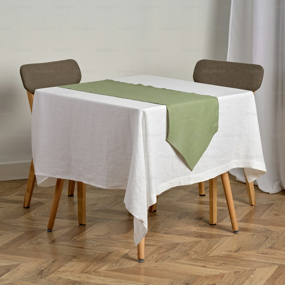 une table avec une nappe blanche et un chemin de table vert