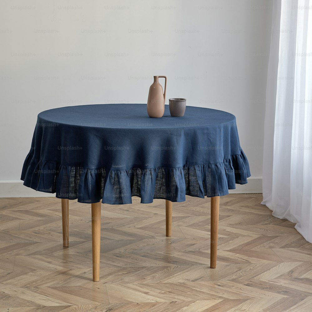 a table with a blue tablecloth and a vase on it
