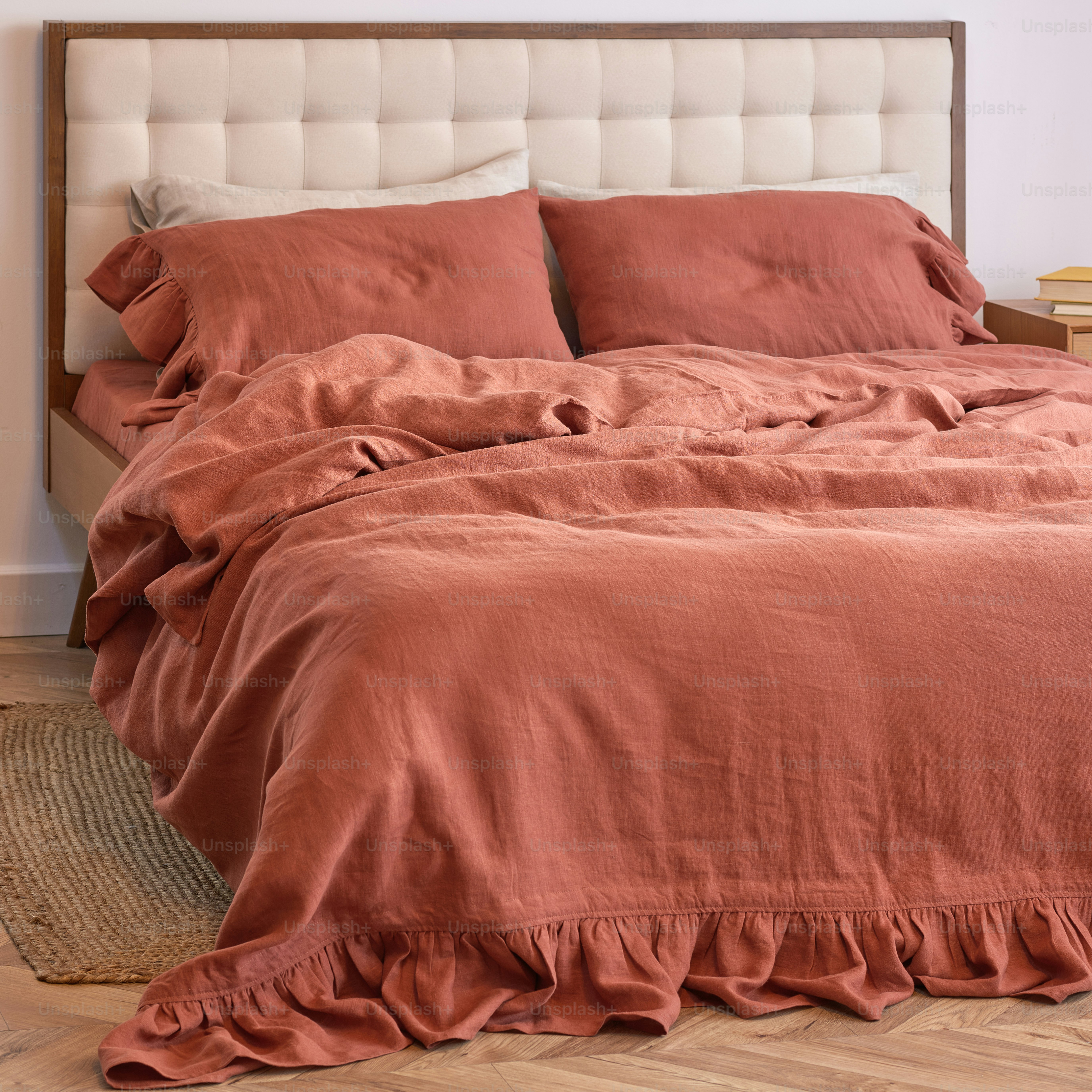 uma cama com um edredom vermelho e uma cabeceira branca