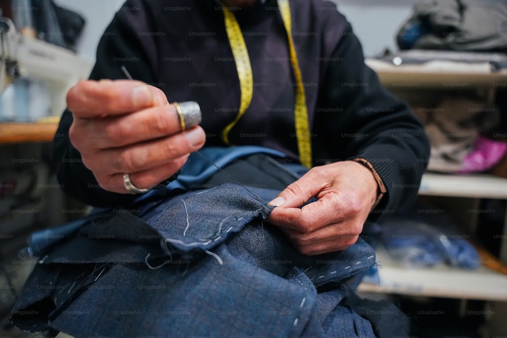 a man working on a pair of jeans