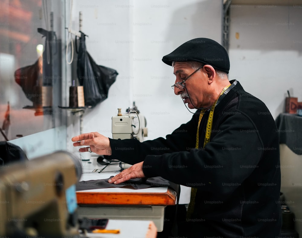 um homem mais velho que trabalha em uma máquina de costura
