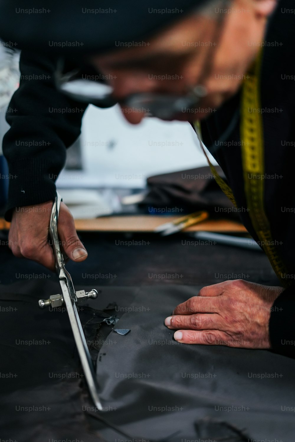 a man is working on a piece of fabric