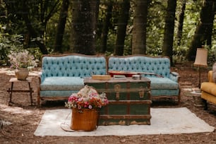 a blue couch sitting next to a wooden trunk