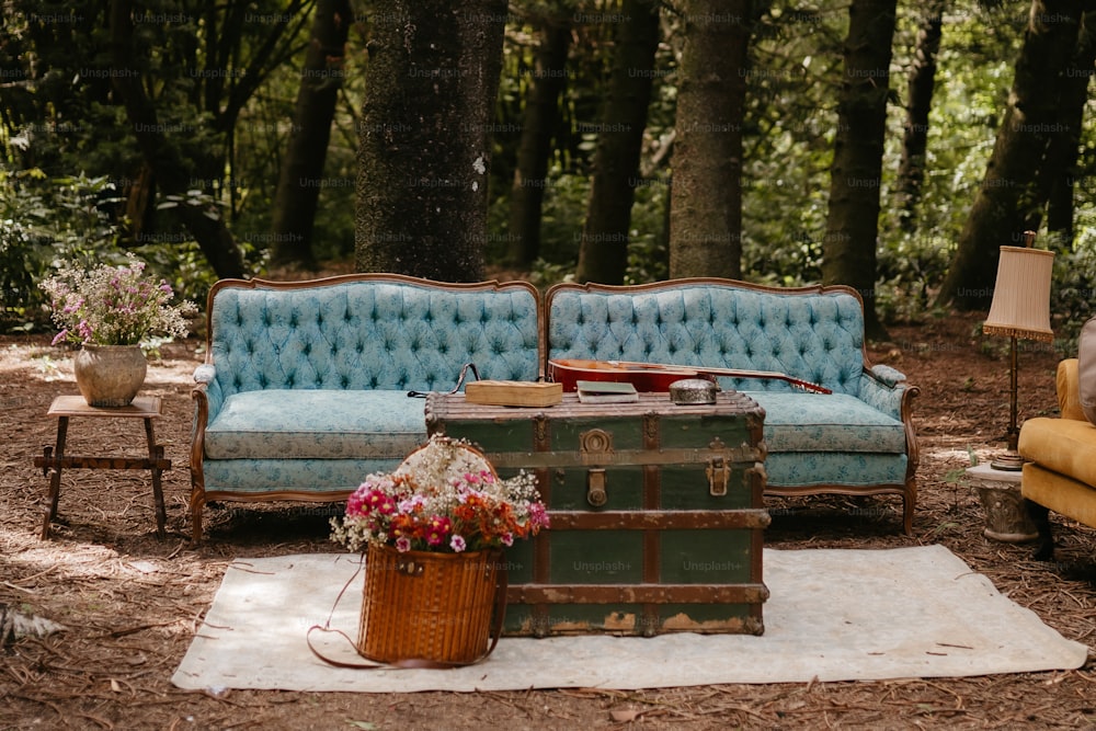 Un sofá azul sentado junto a un baúl de madera