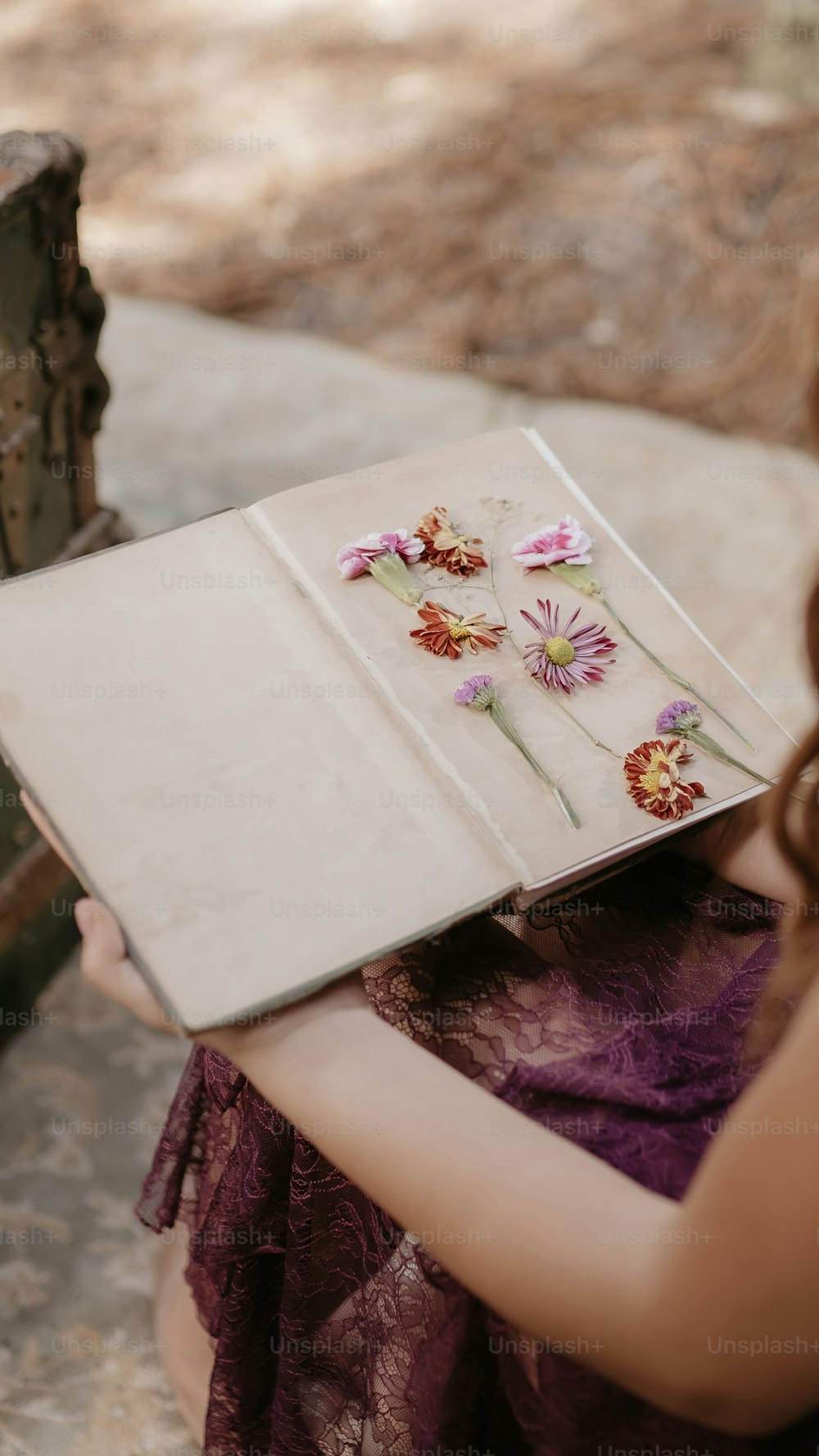 uma mulher segurando um livro com flores sobre ele