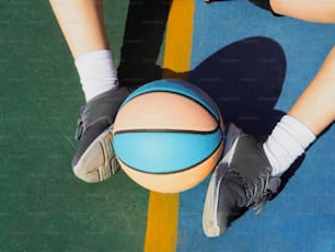 a person standing next to a basketball on a court