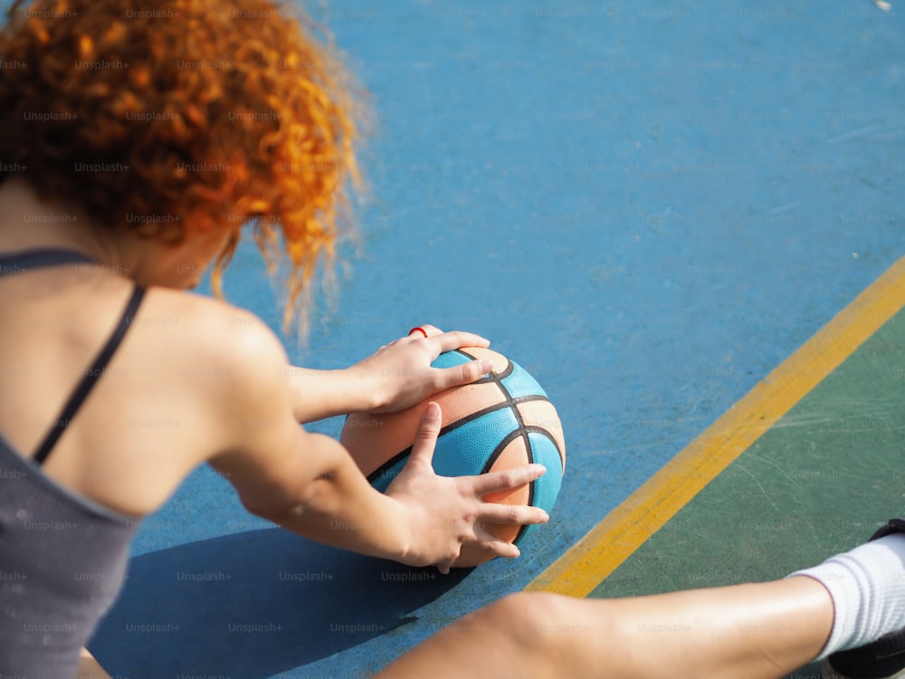a woman holding a basketball on a court