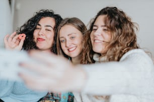 three women taking a picture with their cell phone