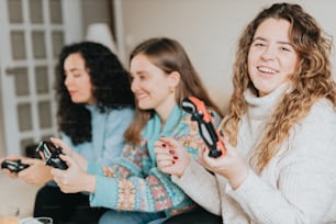 three women sitting on a couch playing a video game