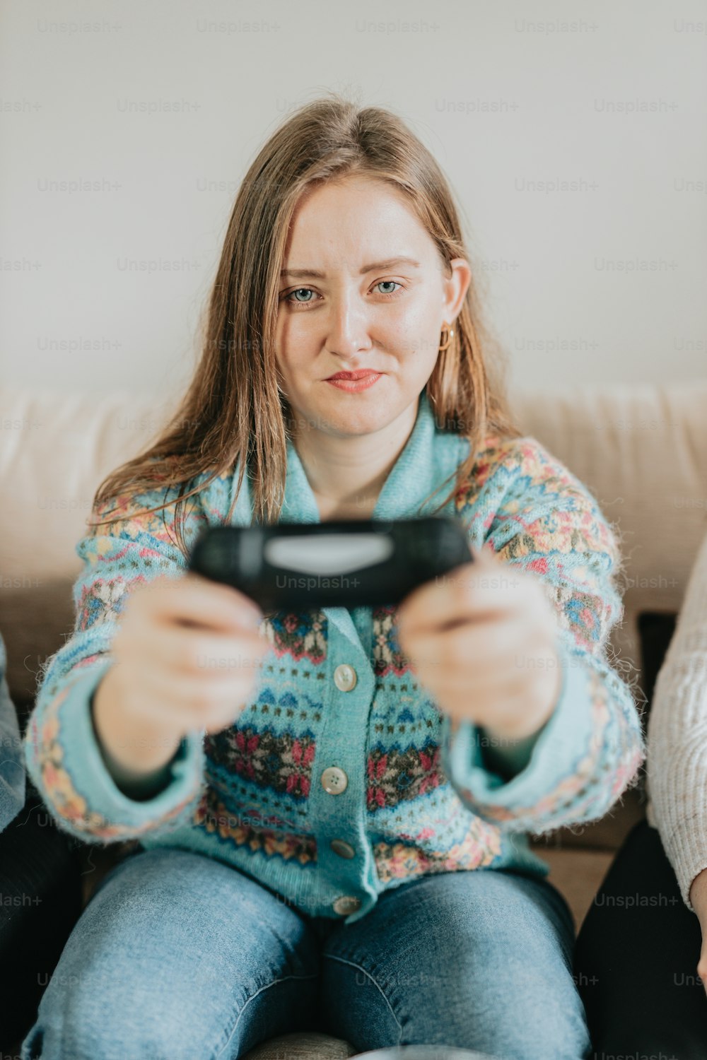a woman sitting on a couch holding a remote control