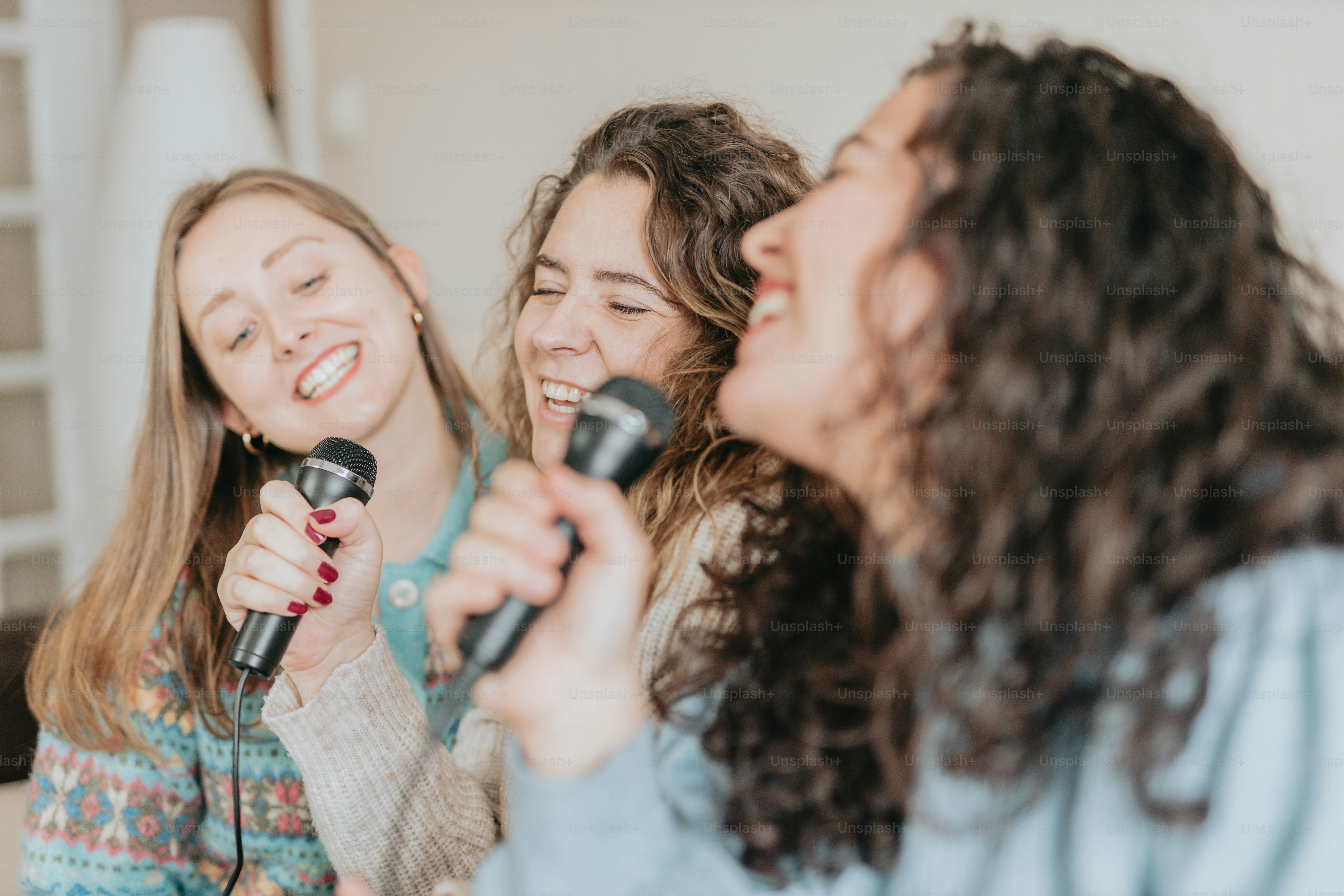 sekelompok wanita berdiri bersebelahan memegang mikrofon