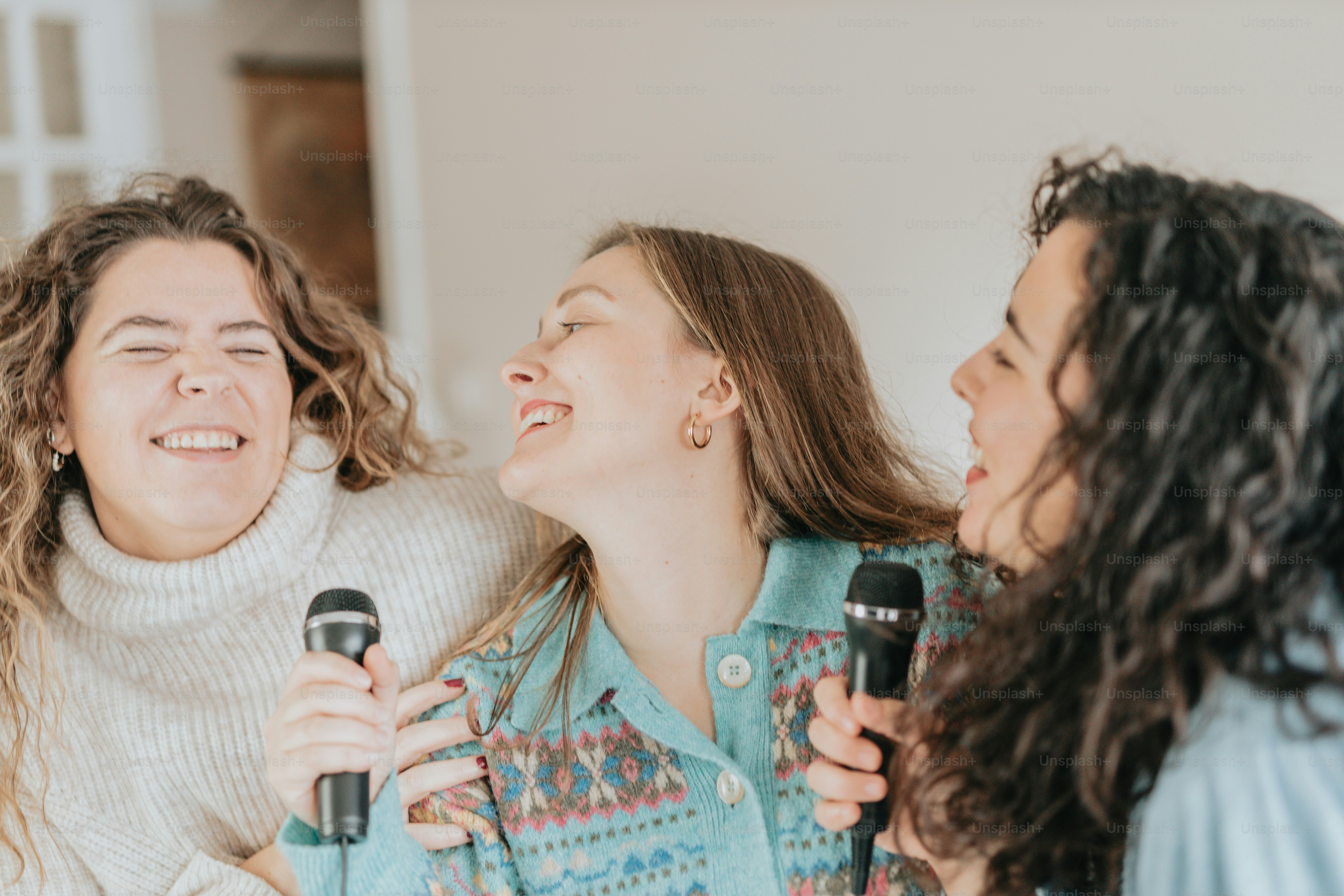 Un grupo de mujeres de pie una al lado de la otra sosteniendo micrófonos