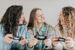 three women laughing and playing a video game