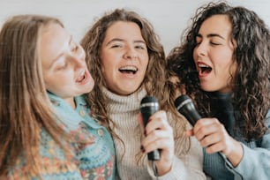 a group of women singing into a microphone