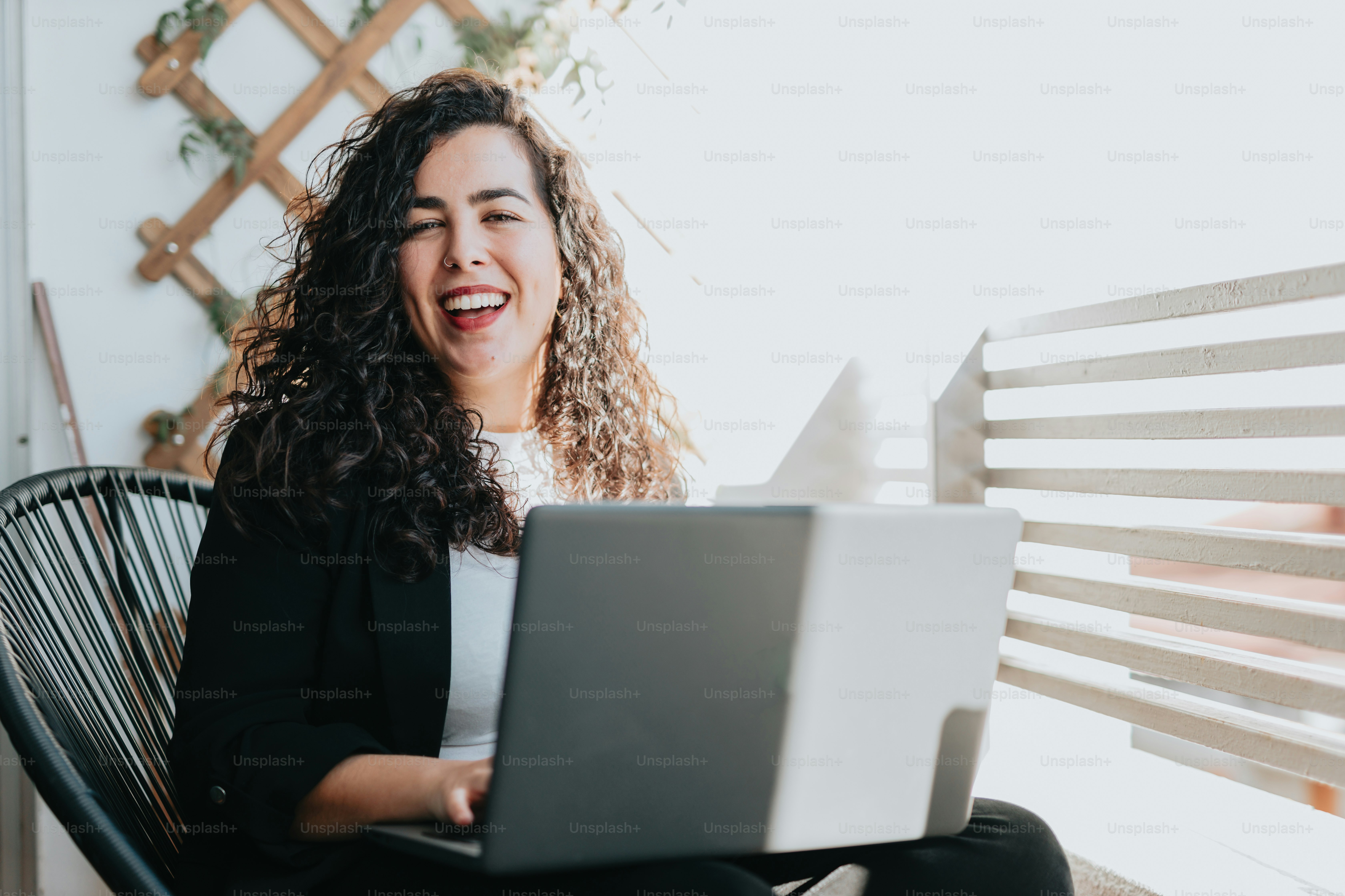 ノートパソコンを持って椅子に座っている女性