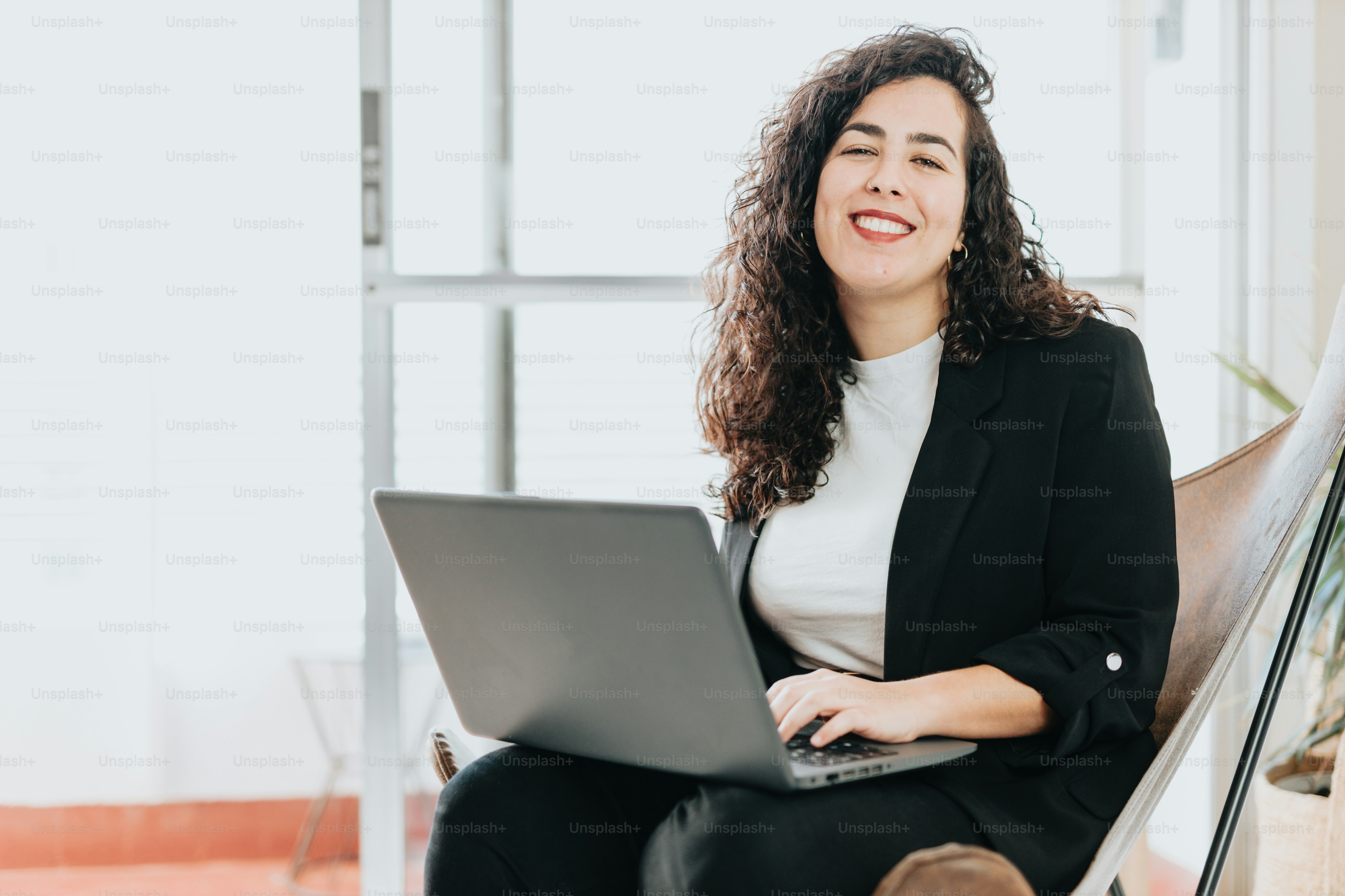 a woman sitting in a chair with a laptop