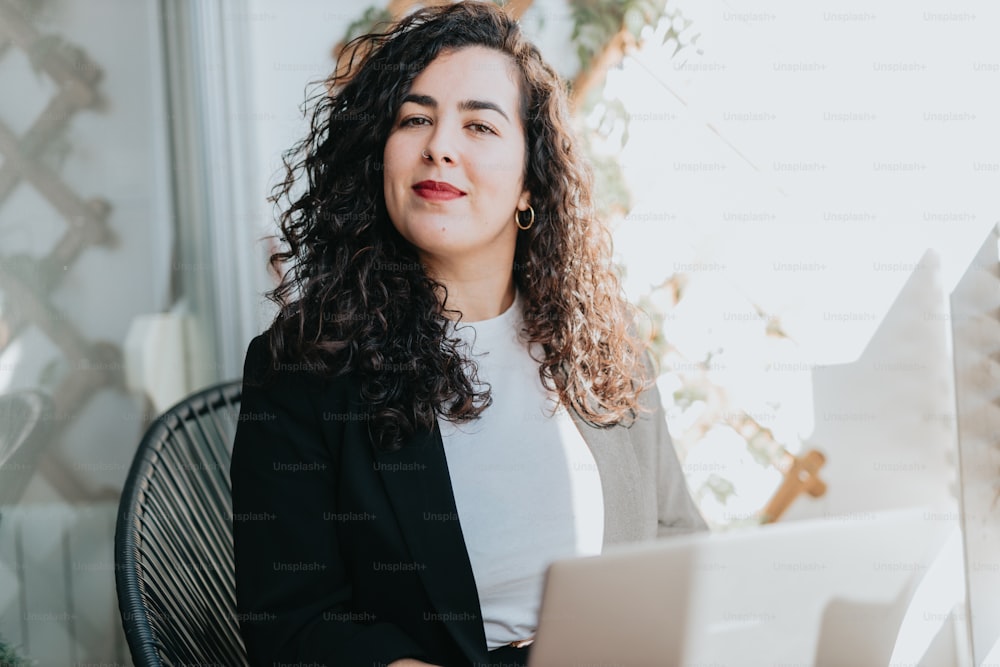 a woman sitting at a table with a laptop