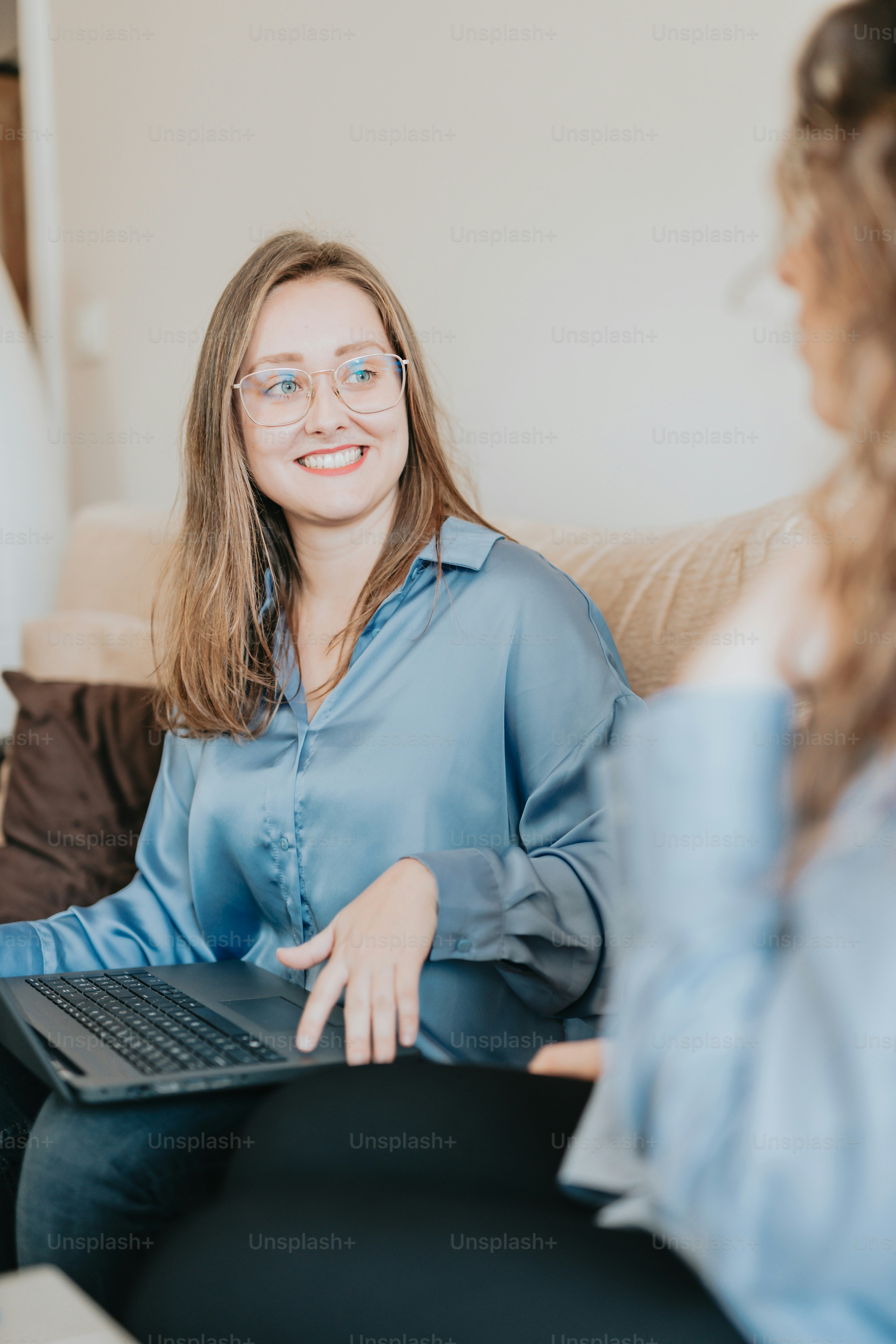 a woman sitting on a couch with a laptop