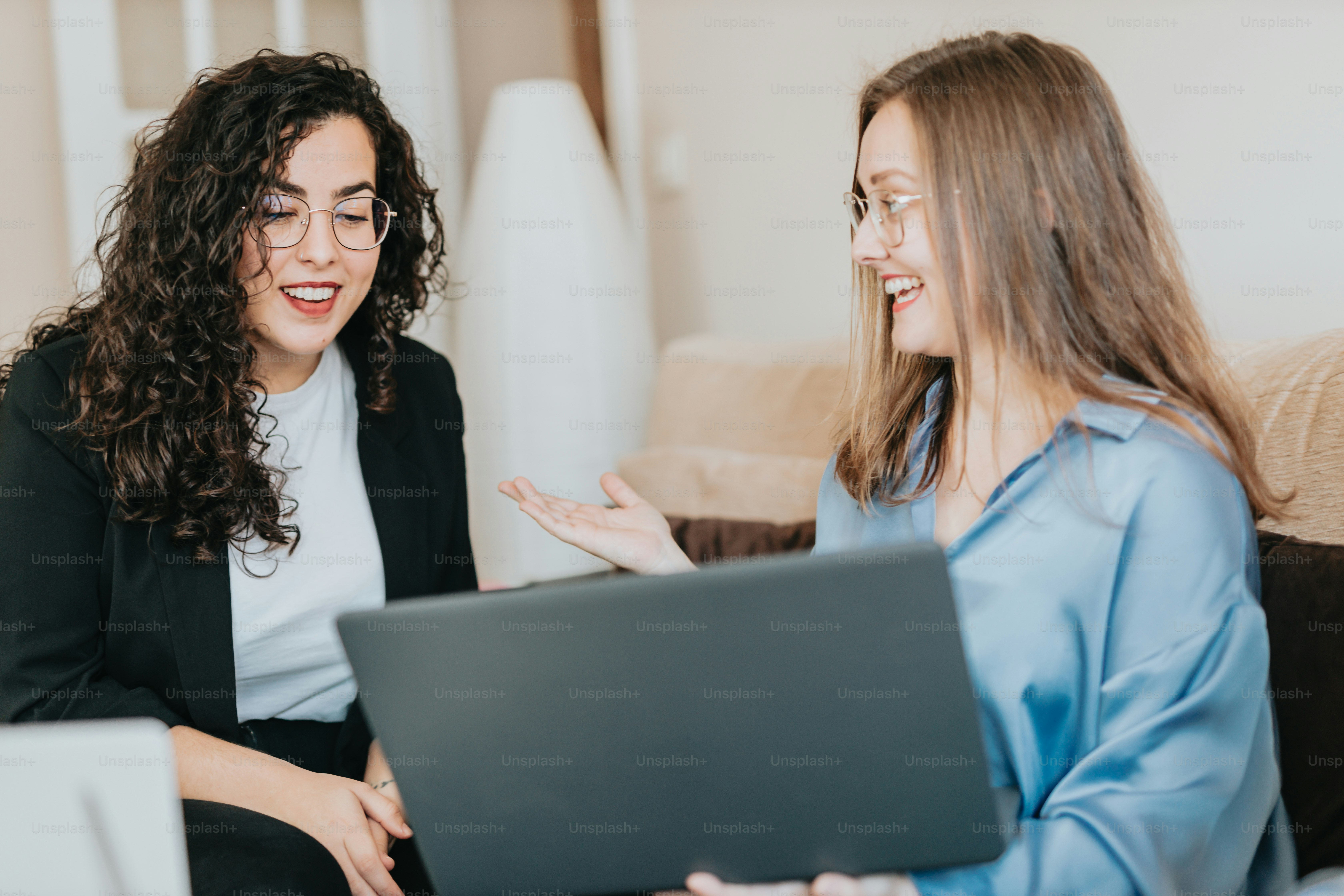 two women sitting on a couch talking to each other