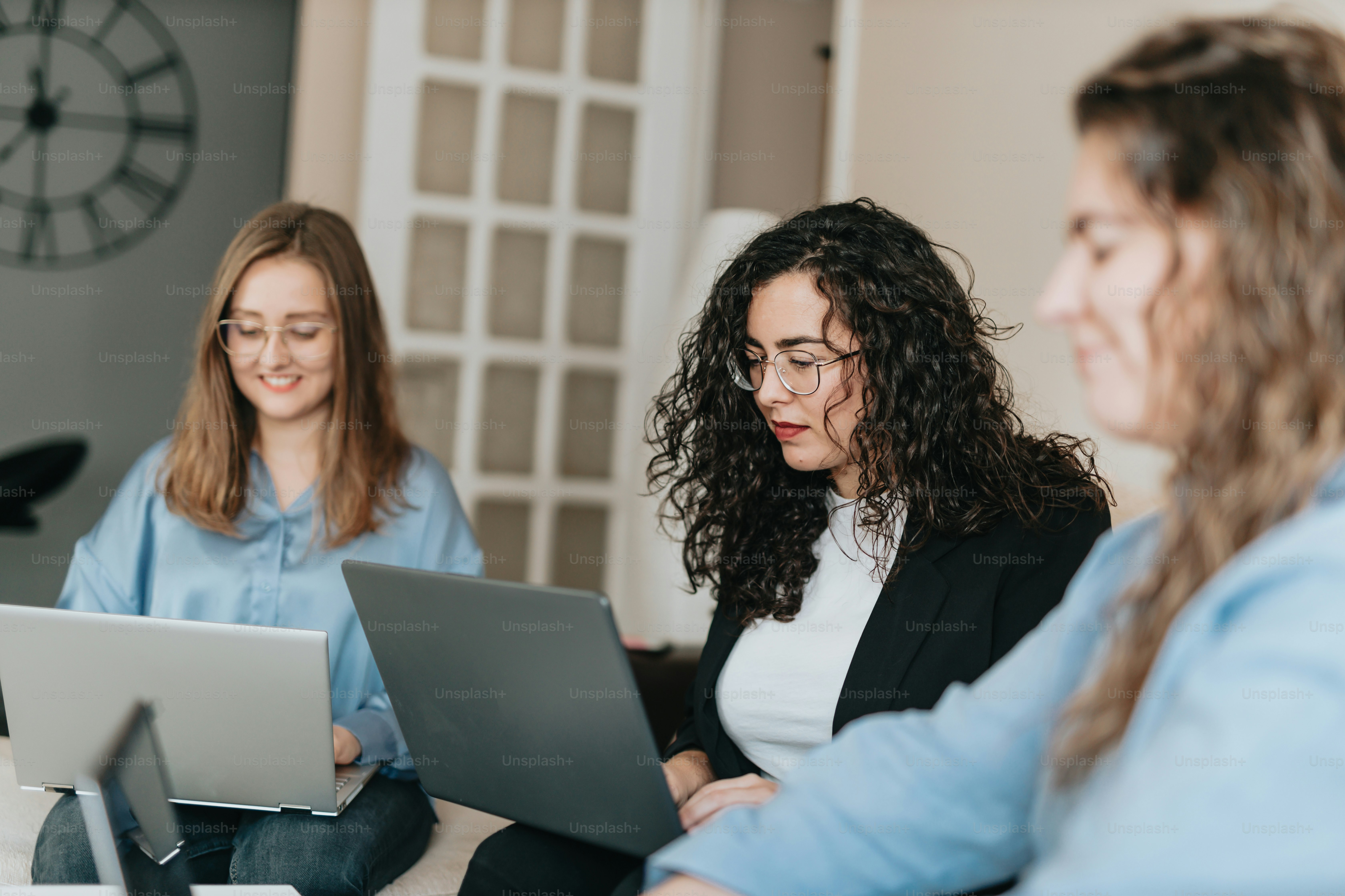 a group of women sitting around a laptop computer