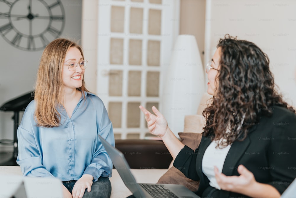 Due donne sedute su un divano che parlano tra loro