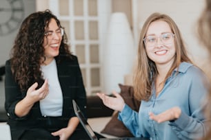 two women sitting on a couch talking to each other