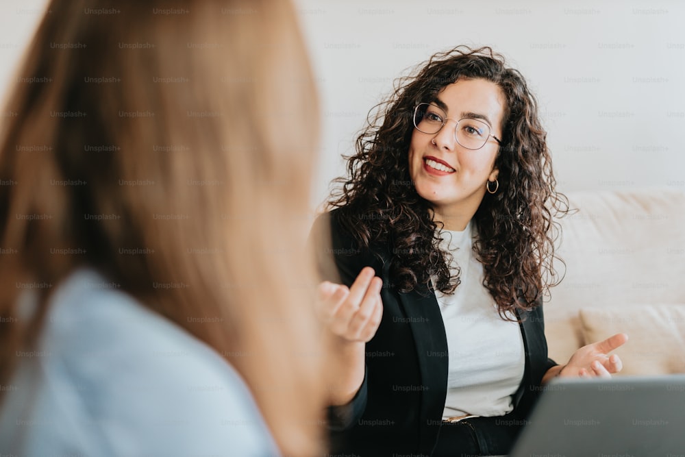 a woman talking to another woman sitting on a couch