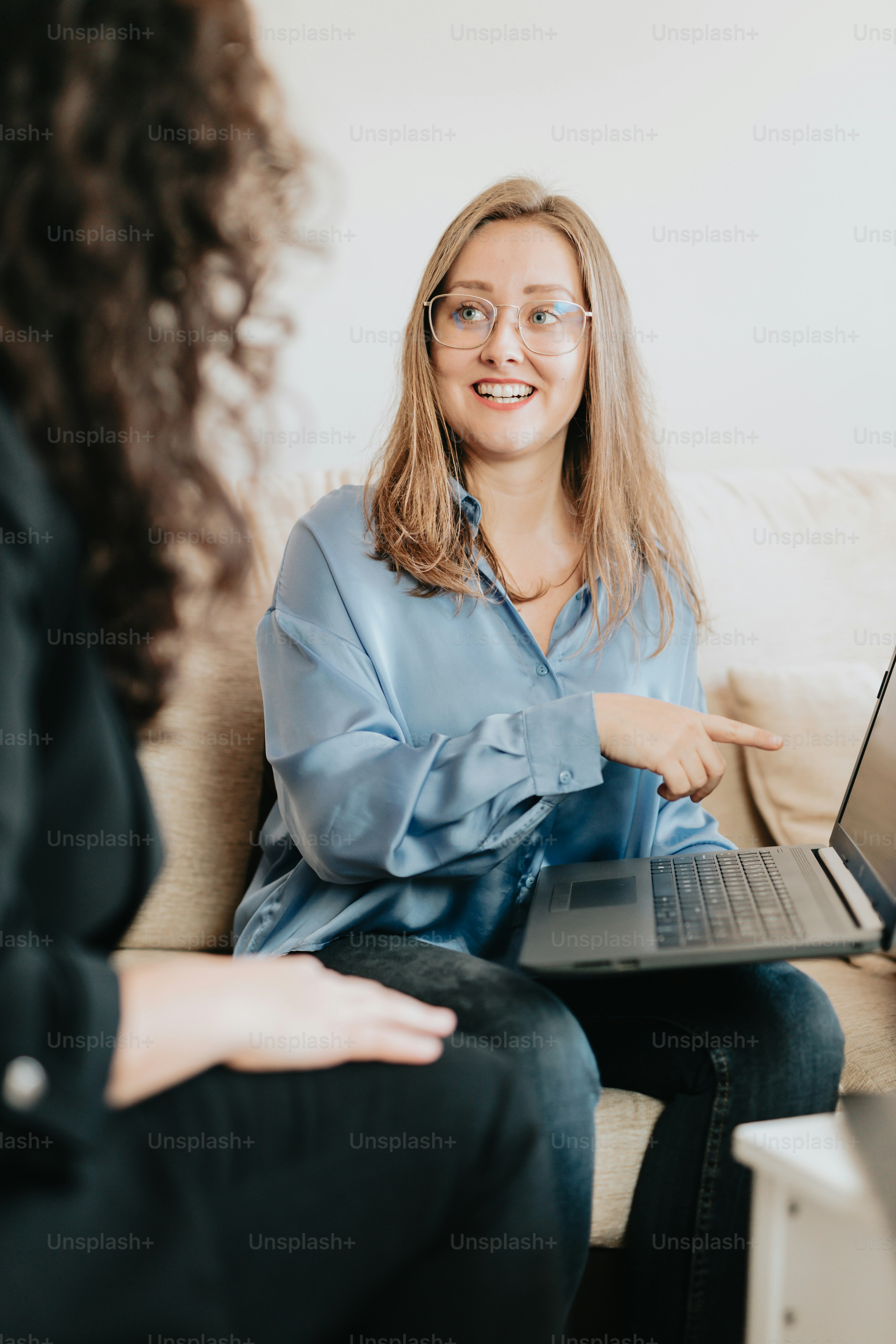 a woman sitting on a couch with a laptop