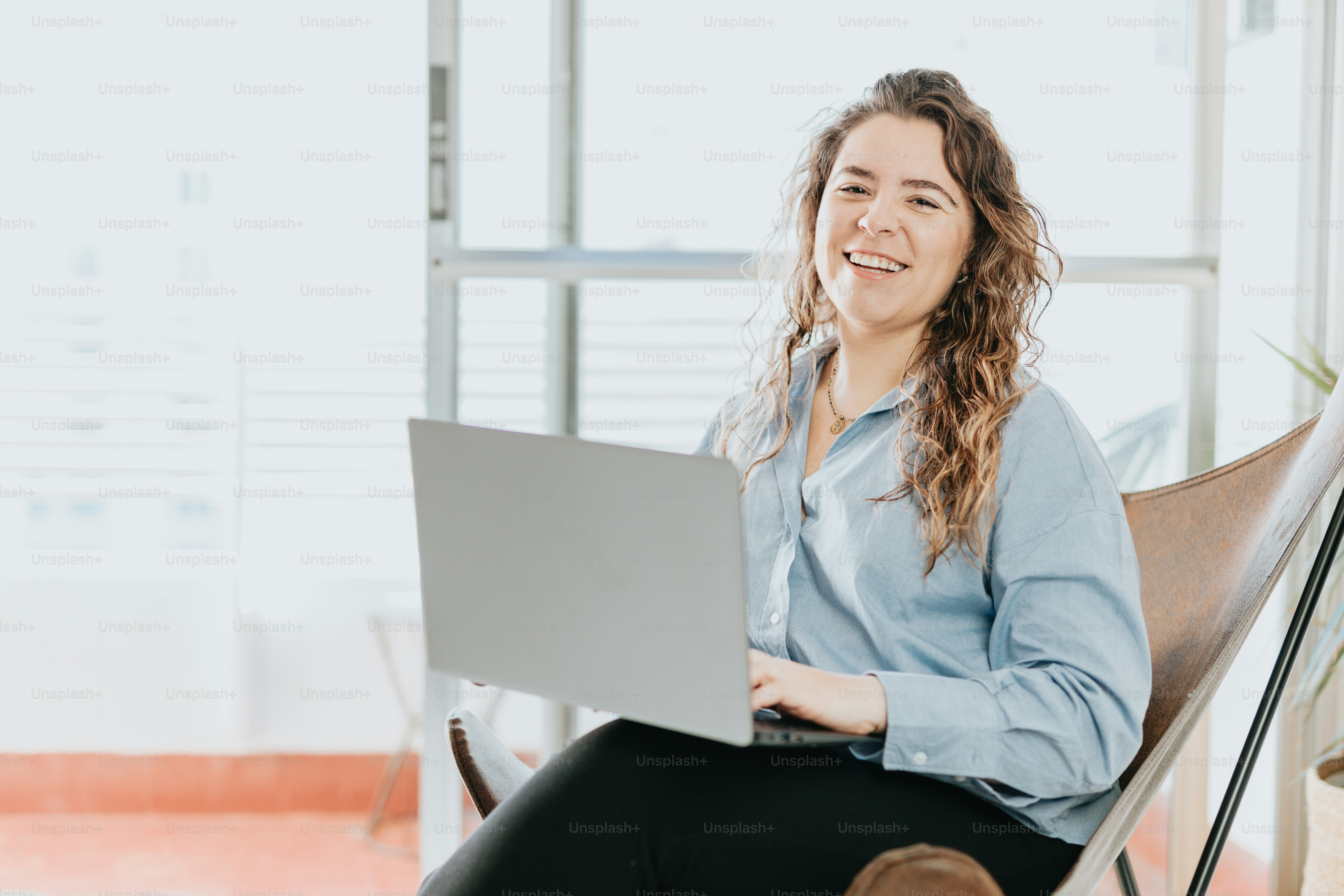 a woman sitting in a chair with a laptop