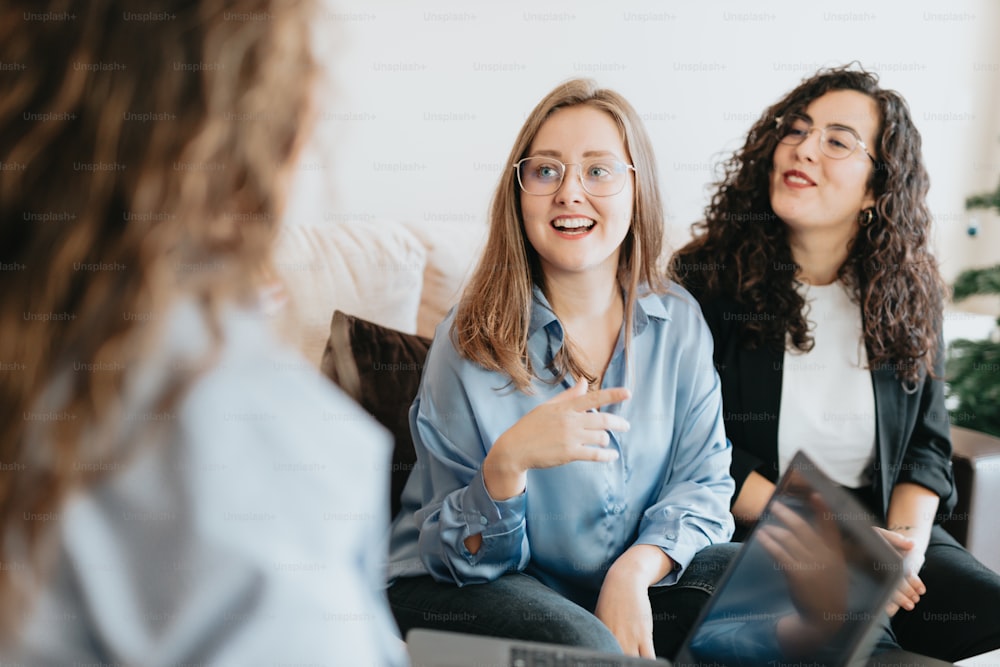 two women sitting on a couch talking to each other