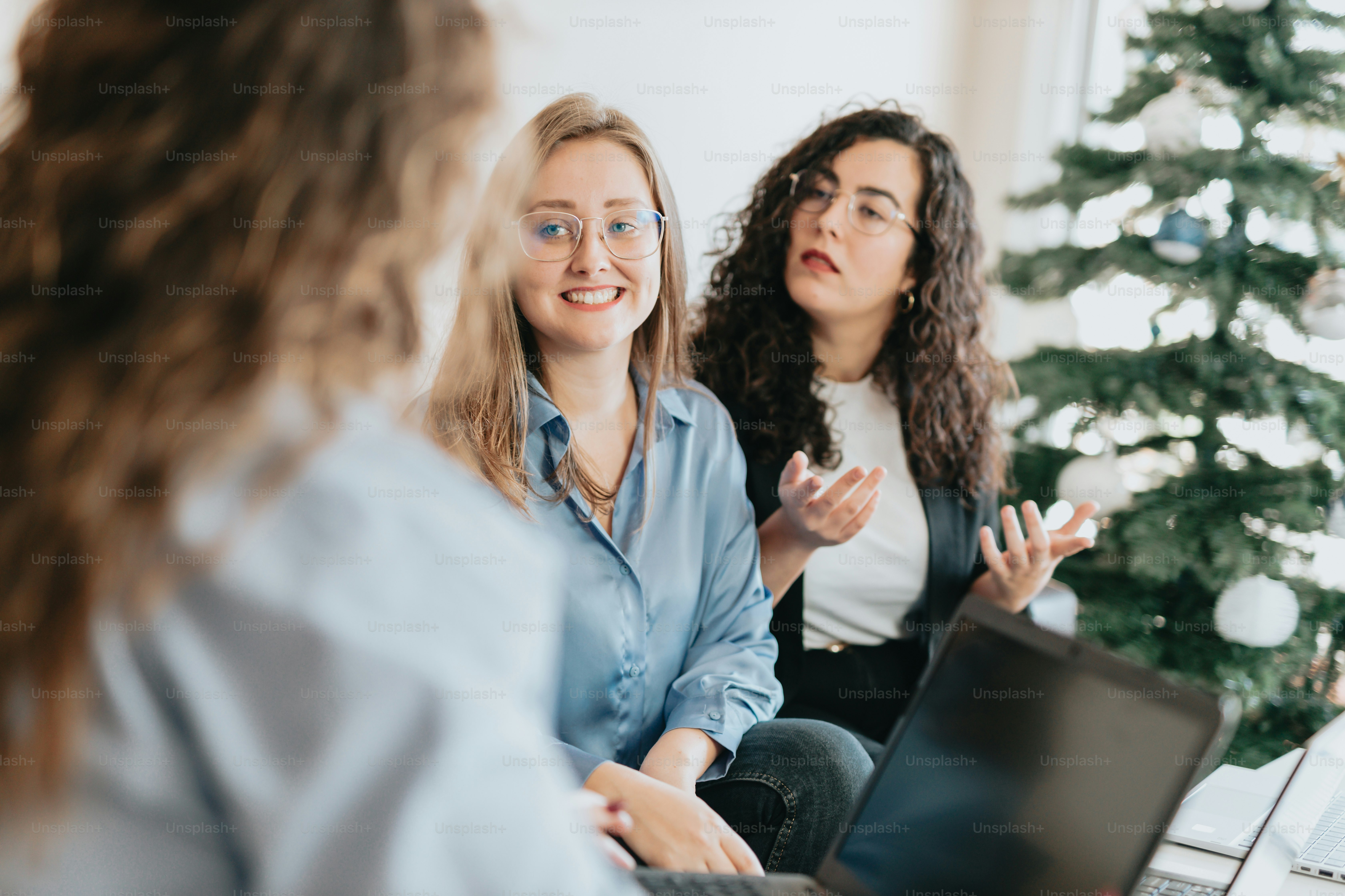 A group of women sitting around a christmas tree photo – Female Image ...