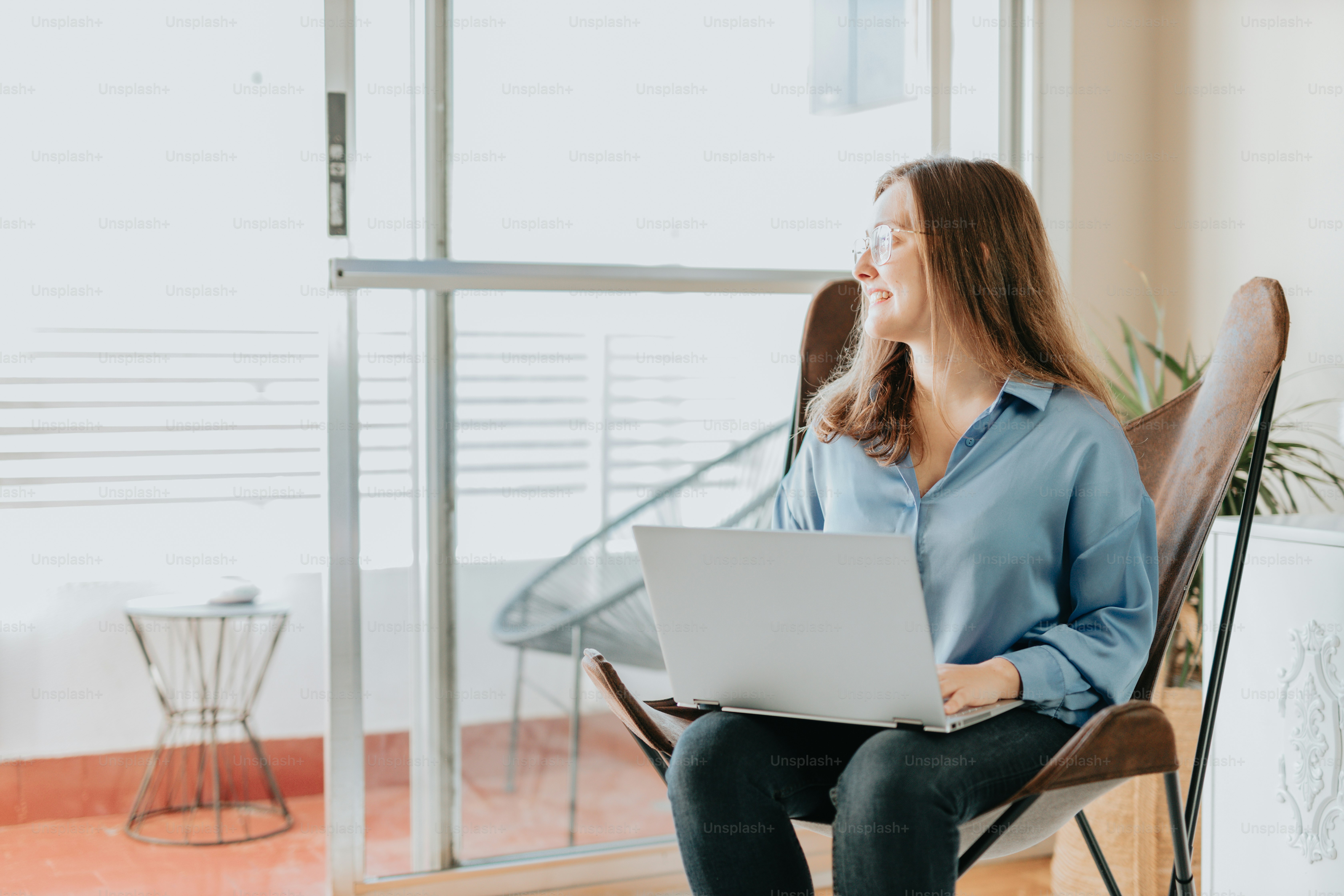 a woman sitting in a chair with a laptop