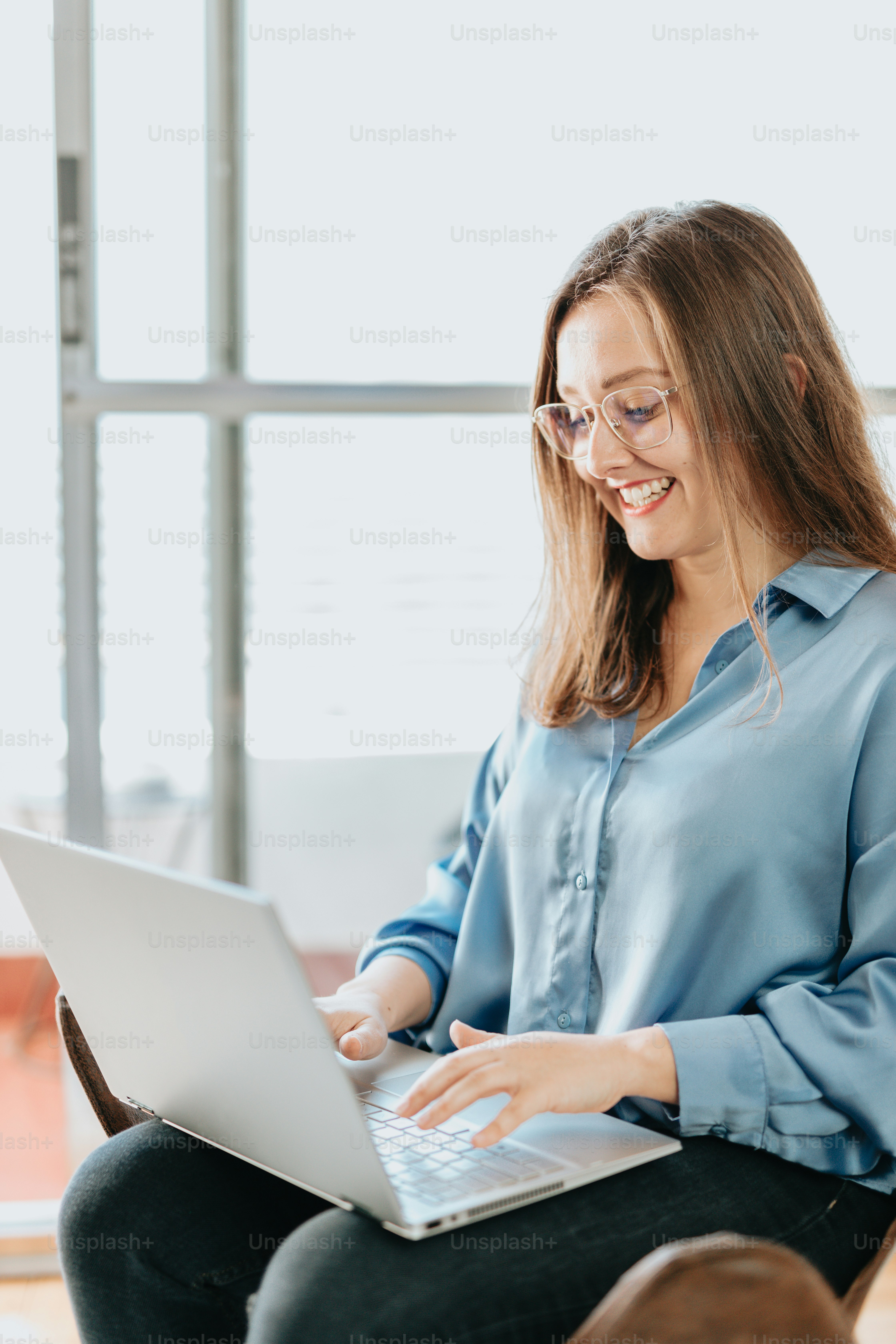 Una donna seduta su una sedia che utilizza un computer portatile