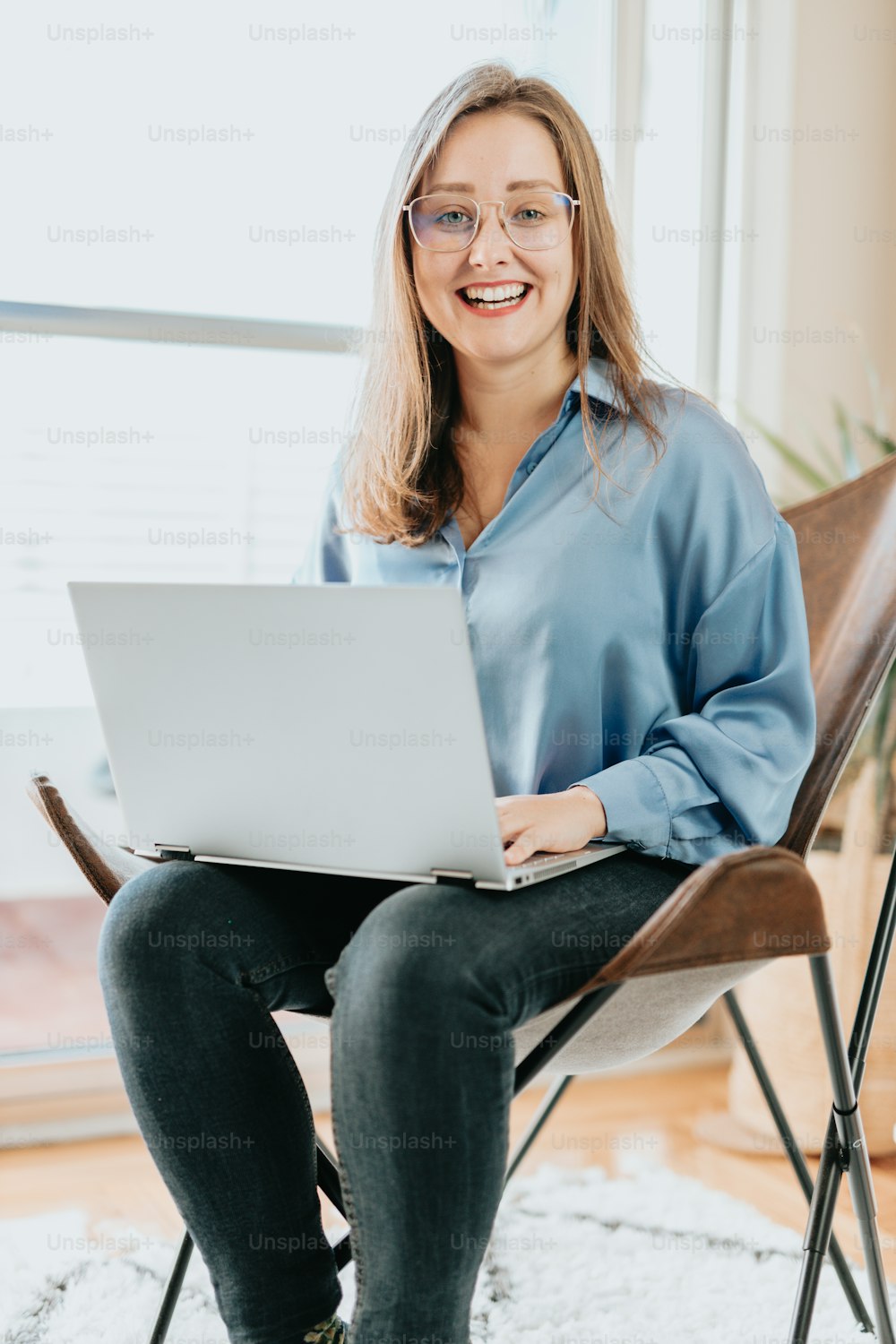 a woman sitting in a chair with a laptop