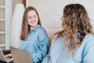 a woman sitting on a couch talking to another woman