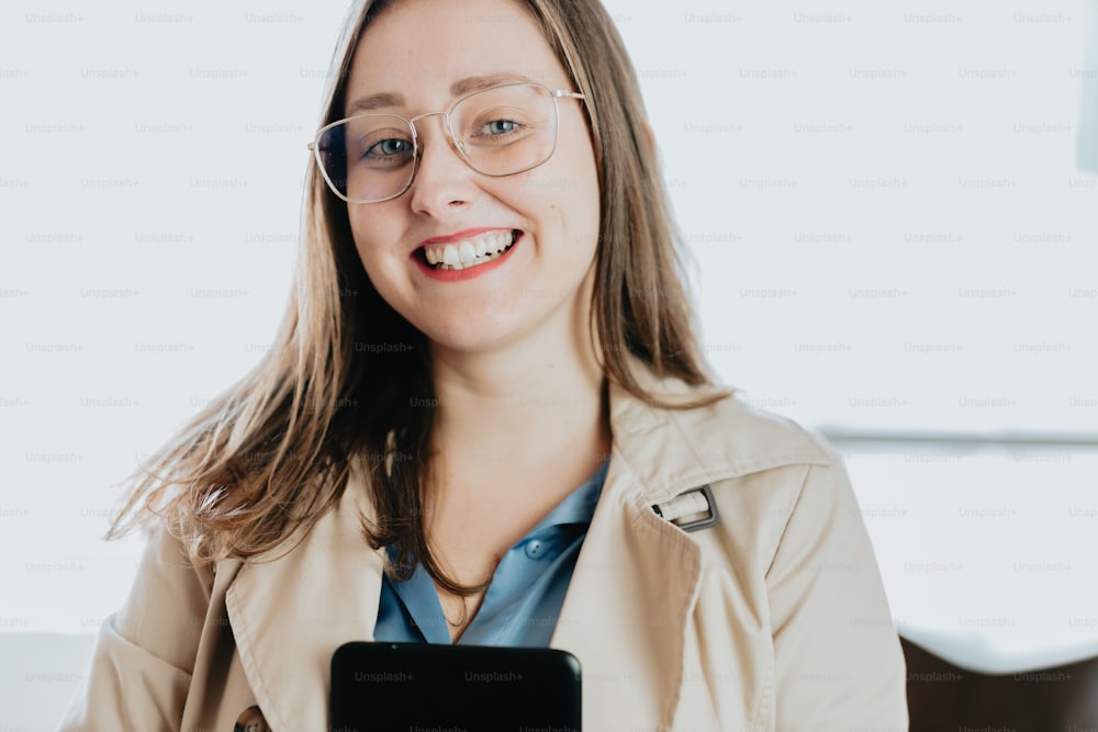 Eine Frau mit Brille hält ein Handy in der Hand