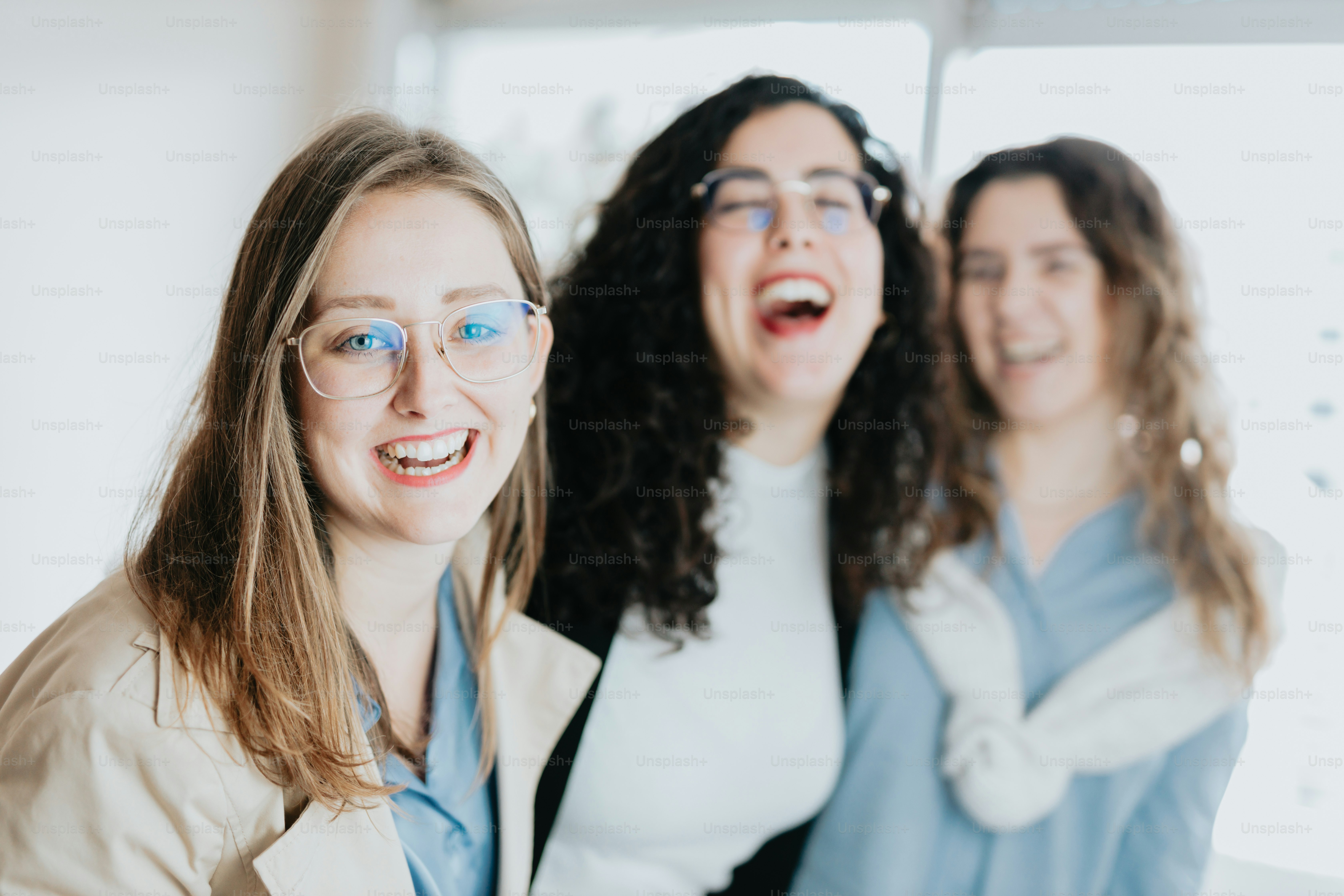 um grupo de três mulheres de pé uma ao lado da outra