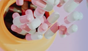 a yellow container filled with lots of pink and white pills