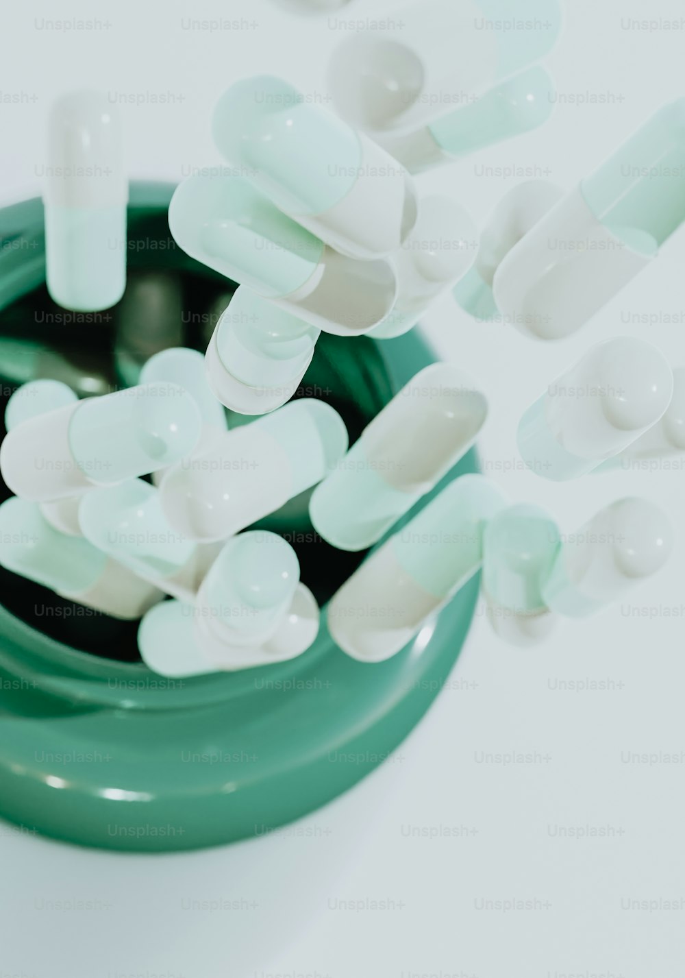 um recipiente verde cheio de pílulas brancas em cima de uma mesa