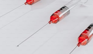 a group of red and silver medical instruments on a white surface