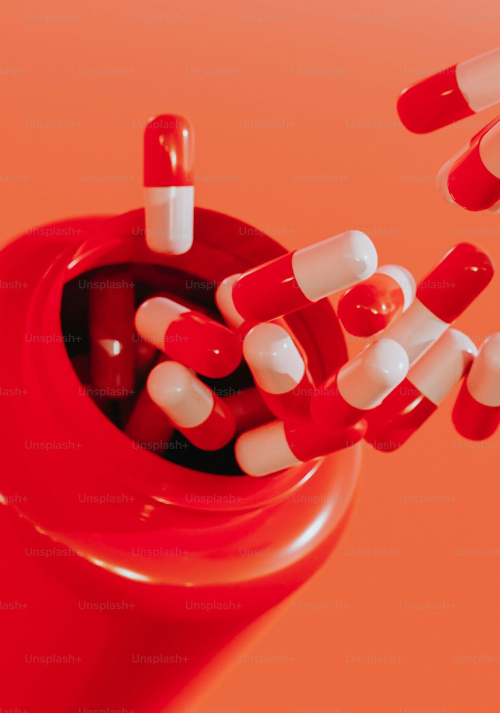 Un frasco de pastillas rojas lleno de pastillas blancas