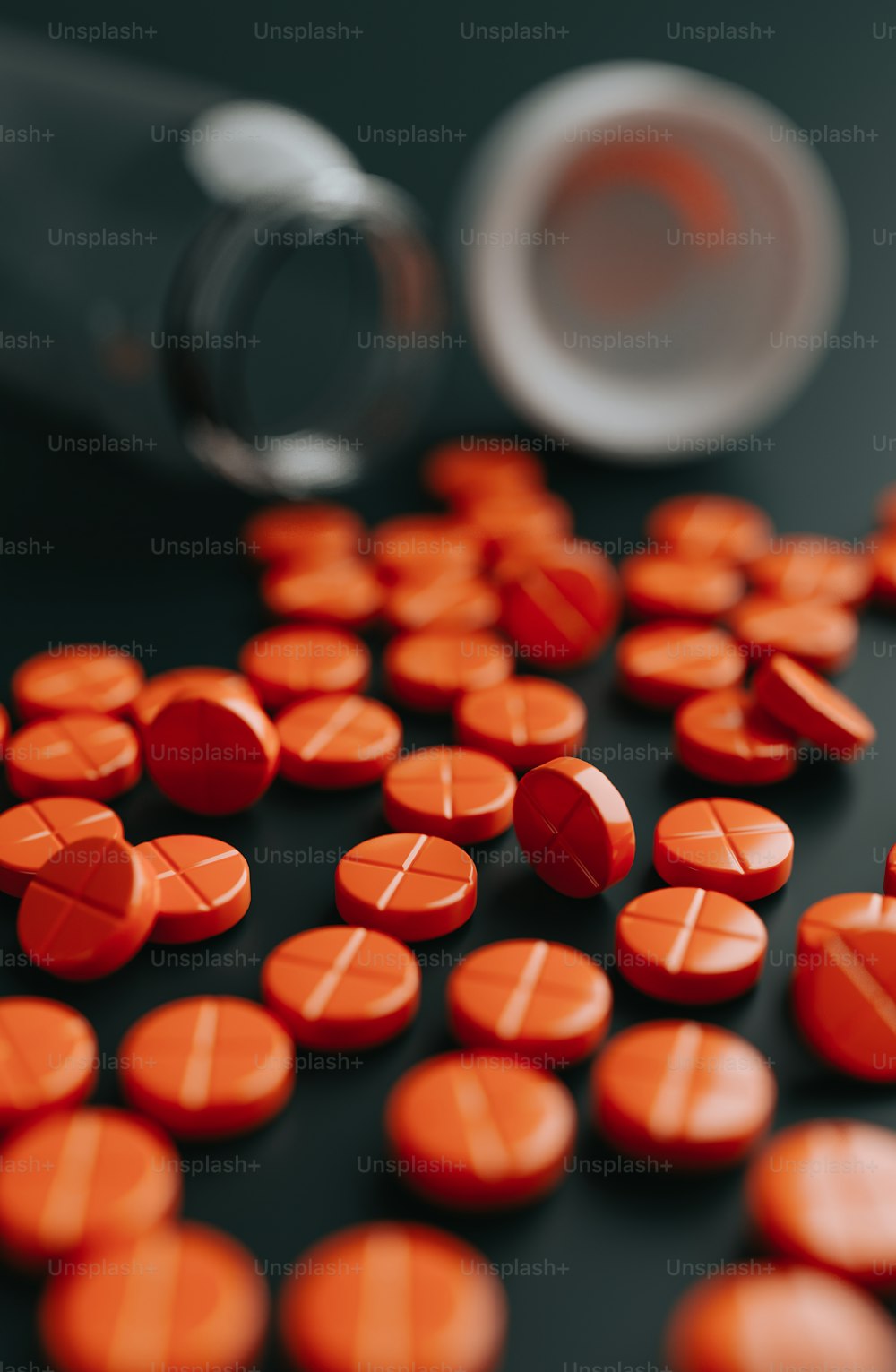 a close up of many orange pills and a bottle