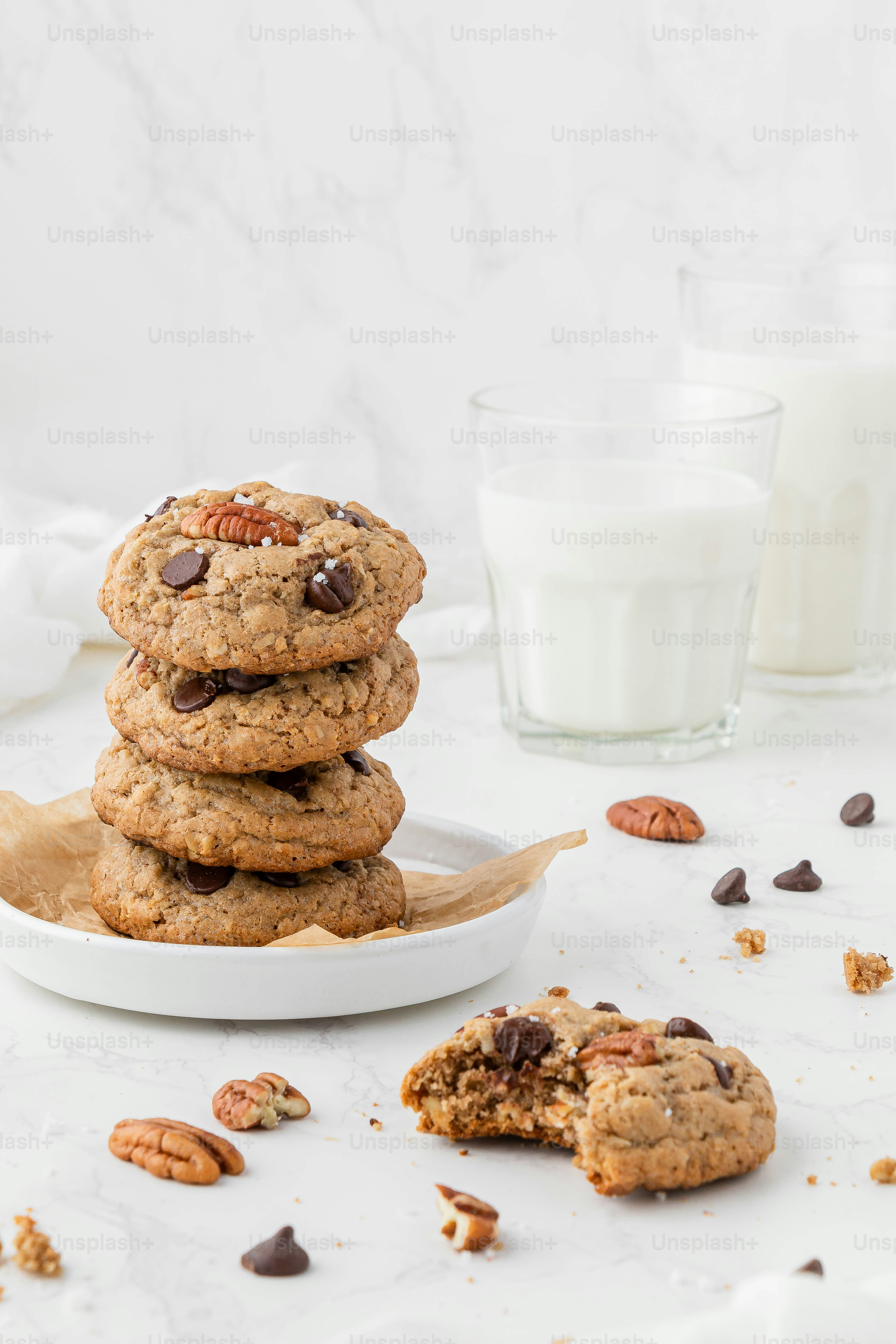 a stack of cookies on a plate next to a glass of milk
