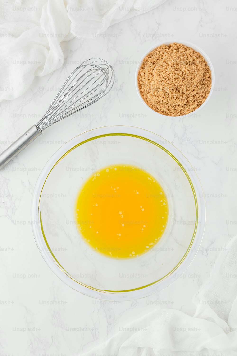a bowl of orange juice, a whisk and a whisk on