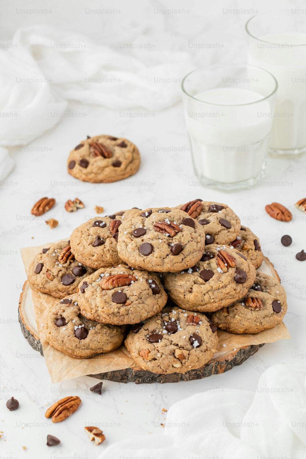 a pile of chocolate chip cookies sitting on top of a wooden board